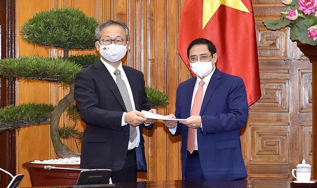 政府总理范明正（右）与日本驻越南大使山田贵雄（图源：越通社）