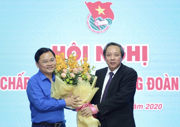 越共中央组织部副部长黄灯光（右）向阮英俊同志赠送鲜花
            （图源：越南之声）