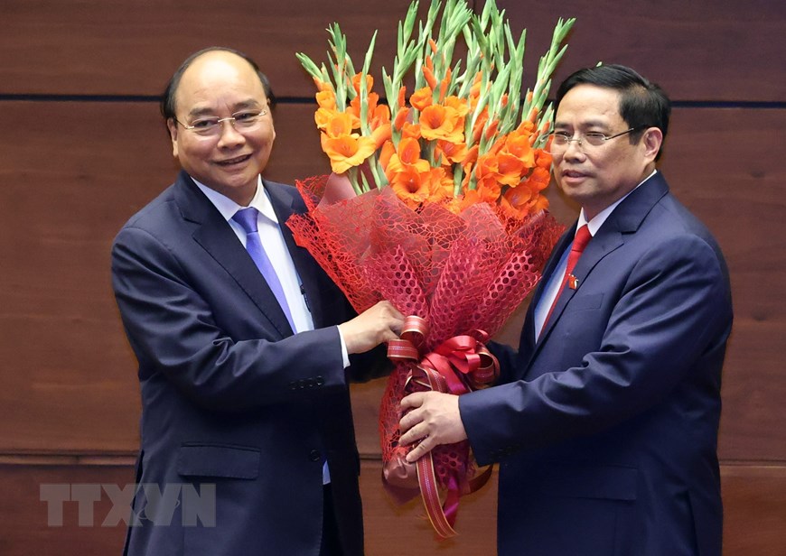 新任政府总理范明正向原政府总理阮春福赠送鲜花