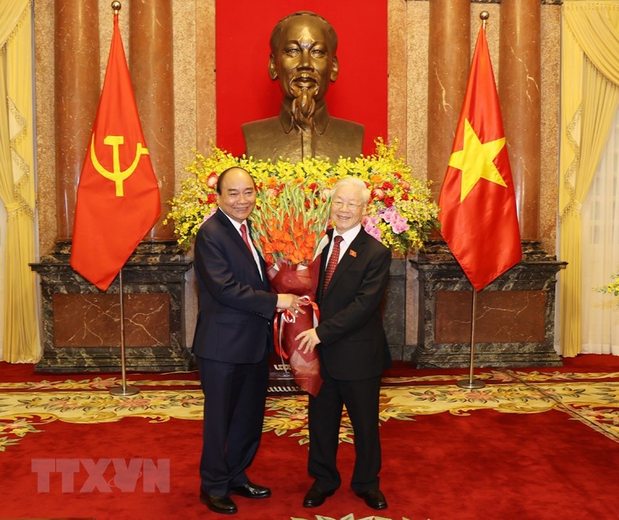 国家主席阮春福向越共中央总书记、前国家主席阮富仲赠送鲜花